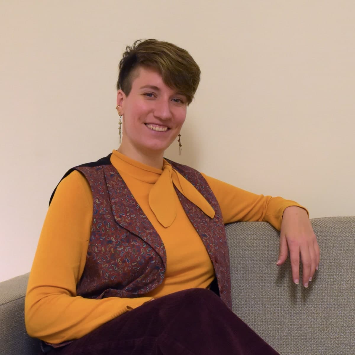 Stefanie Stoppel, Sexualberaterin in Hamburg, sitzt lächelnd auf einem grauen Sofa in ihrer Praxis